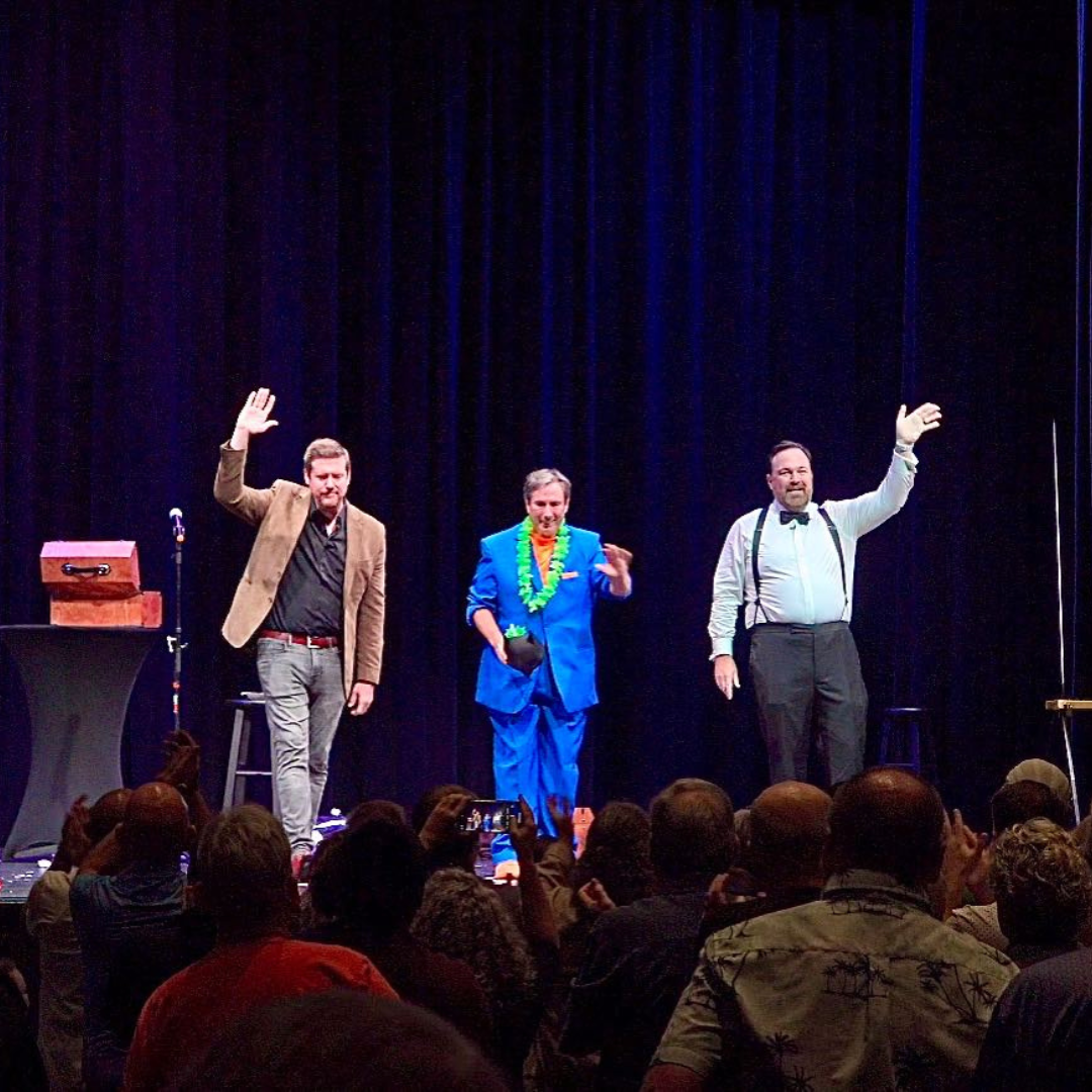 Matt Donnelly joins fellow performers on stage, waving to an enthusiastic crowd after a successful and unforgettable magic show.